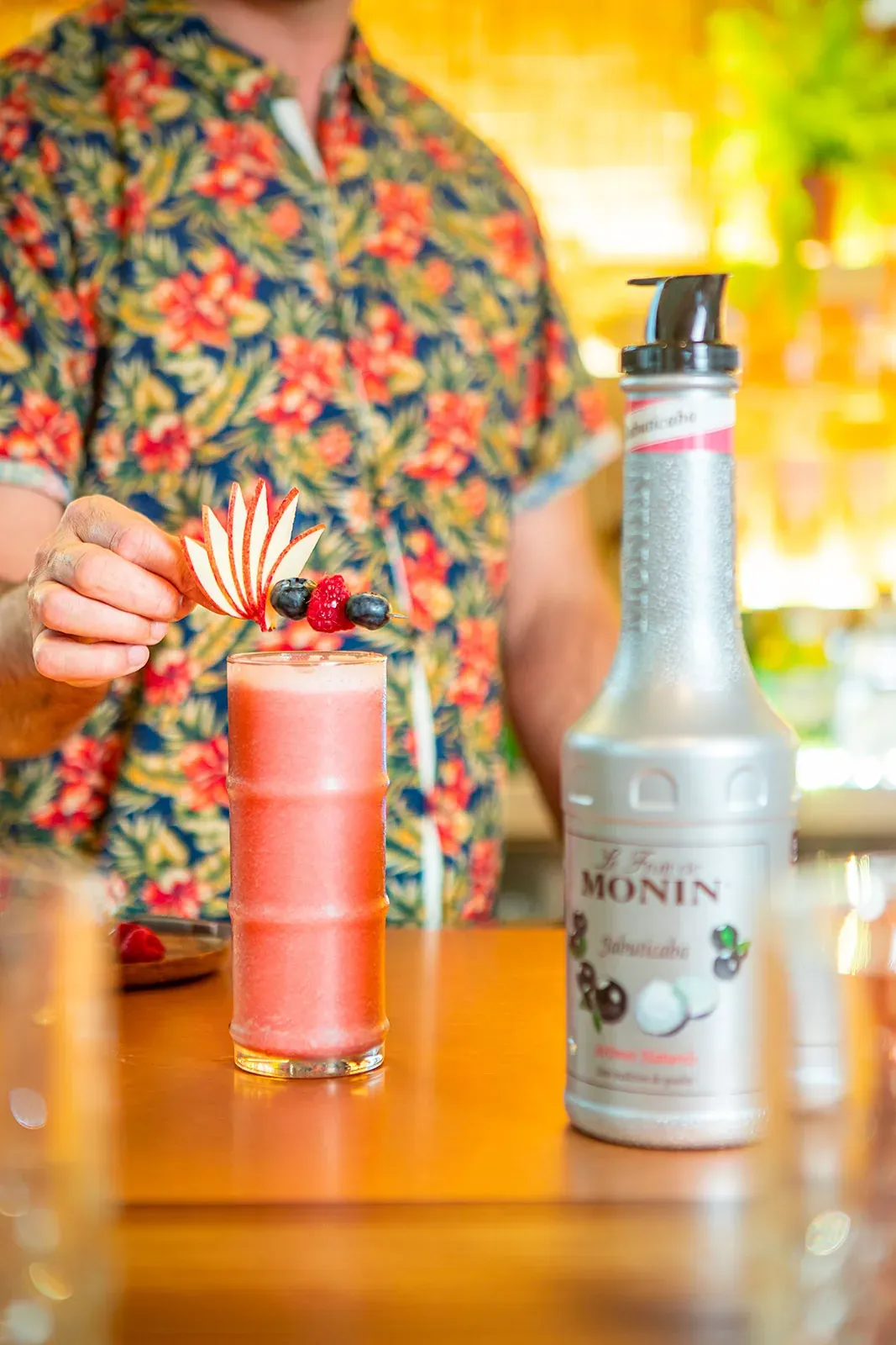 Barman dokončuje růžový koktejl z pyré MONIN Jabuticaba